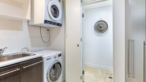 Uma lavanderia moderna com máquina de lavar, secadora e varal.