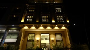 A multi-story hotel with illuminated windows and a central entrance. - Hotel 18 Keys (Bhopal)