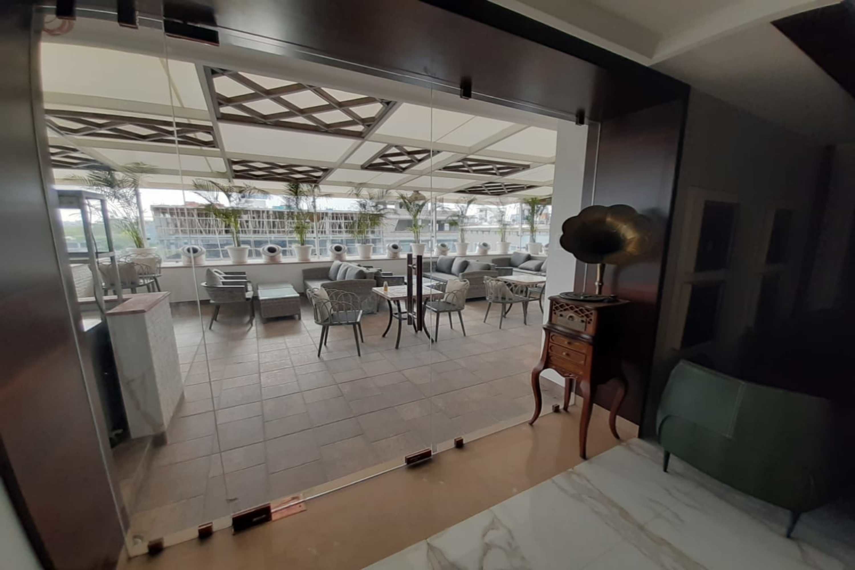 Un interior moderno con comedor, asientos y vistas a través de un separador de vidrio.