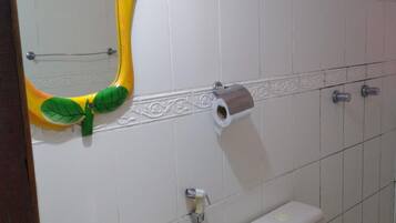 Un baño con un lavamanos blanco, inodoro y espejo con marco amarillo.
