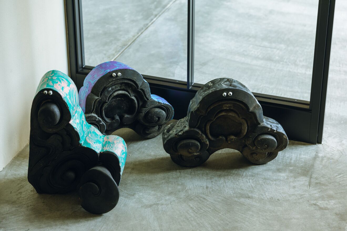 Three decorative objects with googly eyes, placed on a concrete floor near a window.