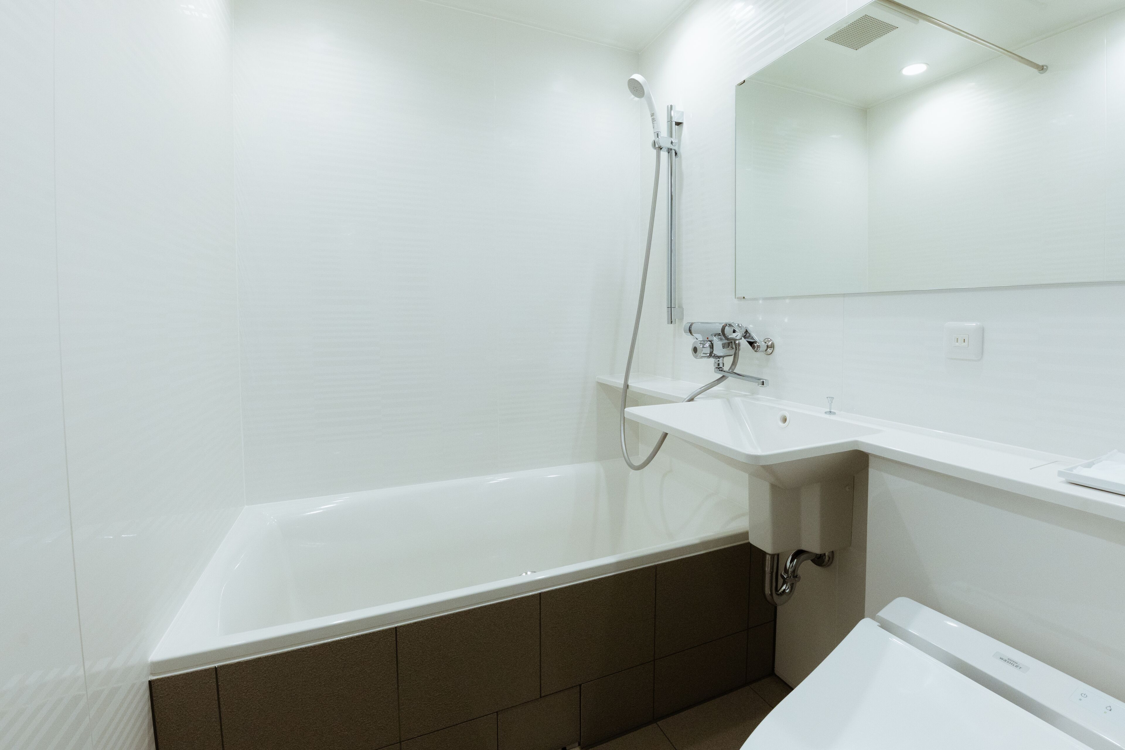 A modern bathroom with a bathtub, a sink, and a mirror.