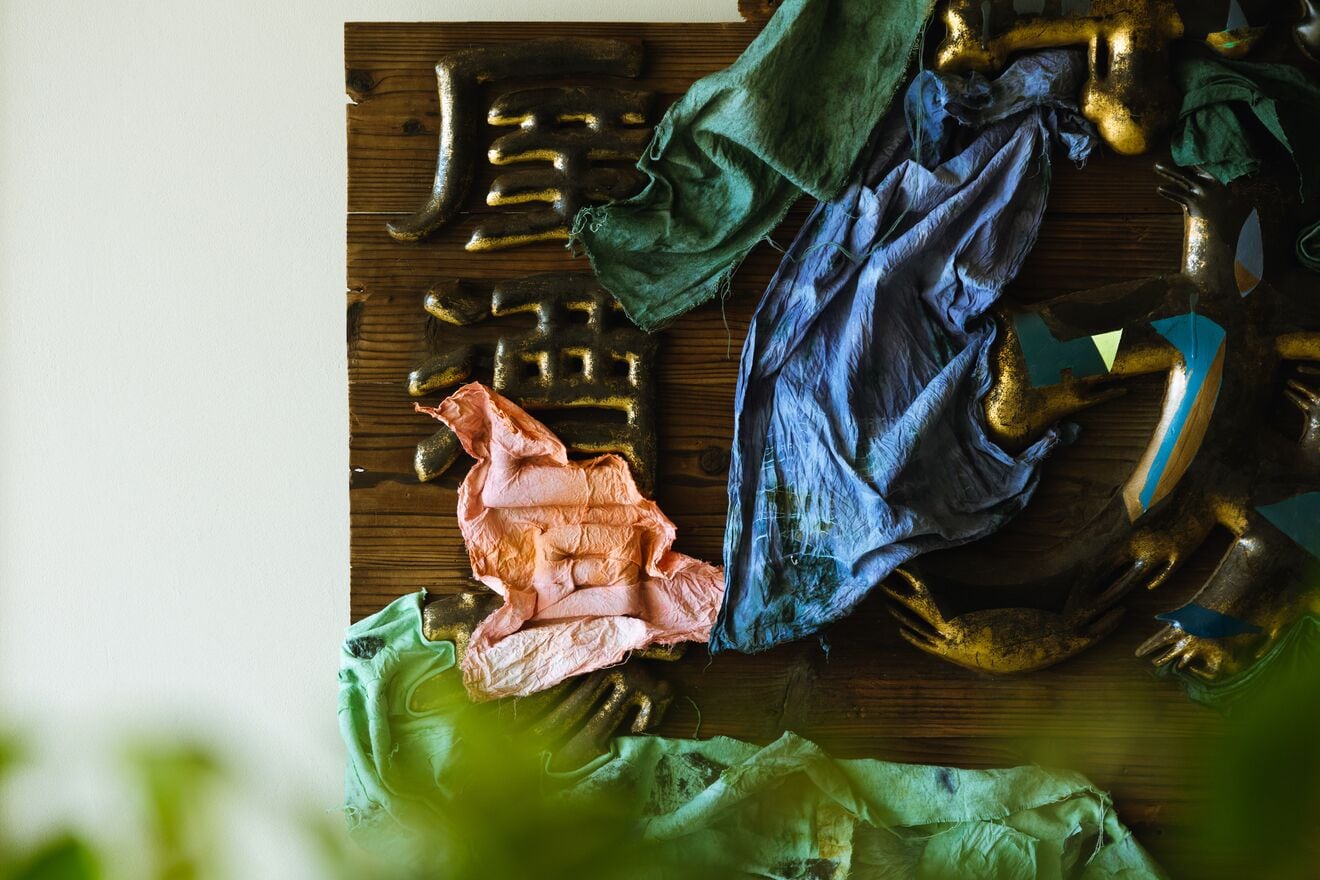 A wooden surface with crumpled fabric pieces in various colors.