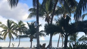 A pool surrounded by palm trees and a beach view. - 506 - 3rd Floor Ocean View Suite (San Pedro)
