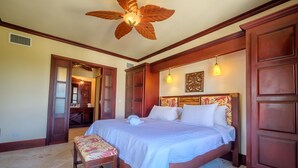 A bedroom with a large bed, wooden headboard, and a ceiling fan. - 506 - 3rd Floor Ocean View Suite (San Pedro)
