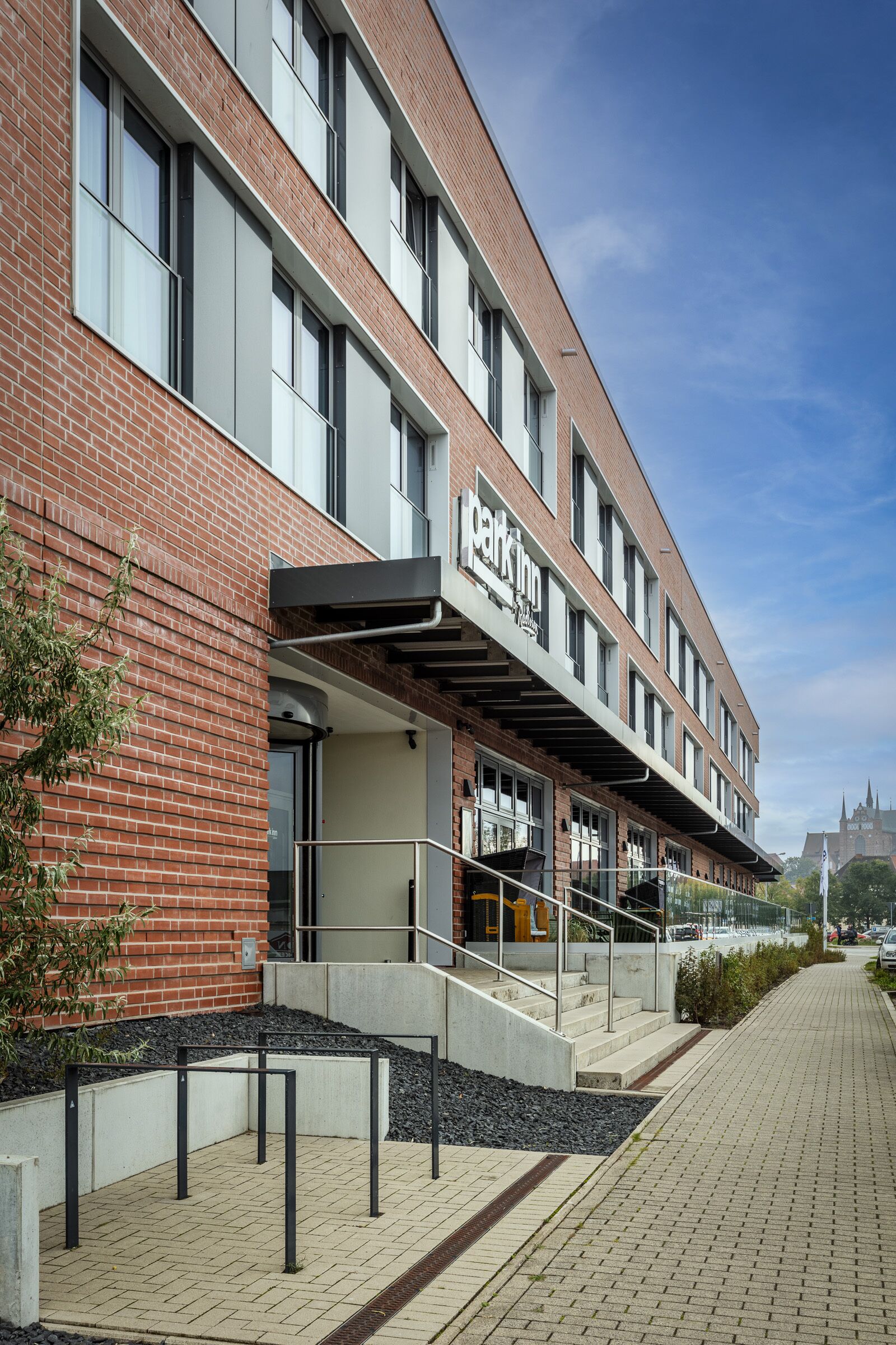 Un bâtiment moderne avec une façade en briques, une entrée couverte et une enseigne de restaurant bien visible.