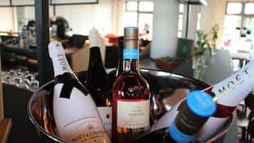 Une sélection de bouteilles de vin dans un récipient en métal, comprenant des marques telles que Moët & Chandon et Rotling, présentée dans un intérieur moderne et bien éclairé.
