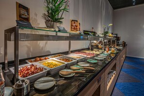 A buffet with various food items and utensils. - Park Inn By Radisson Wismar (Wismar)