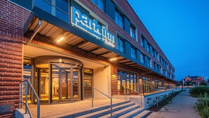 A hotel entrance with a revolving door, a staircase, and a sign that reads "Park Inn." - Park Inn By Radisson Wismar (Wismar)