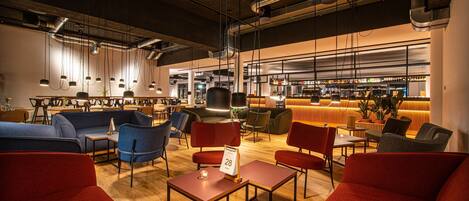 Un espacio lounge moderno con sofás, mesas y sillones dispuestos para socializar.