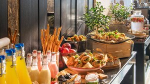 Een buffet met diverse gerechten en drankjes, zoals fruit, brood en toevoegingen.