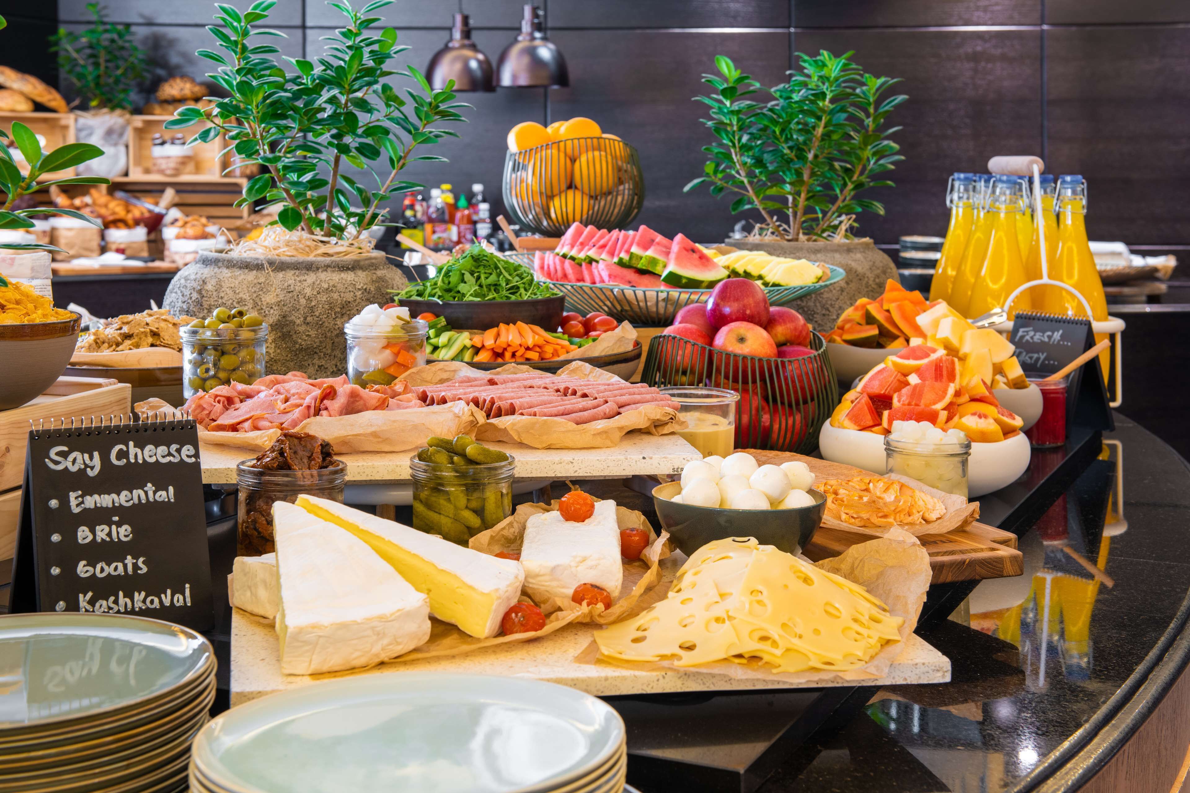 Un buffet proposant une variété de fromages, de fruits et de légumes.