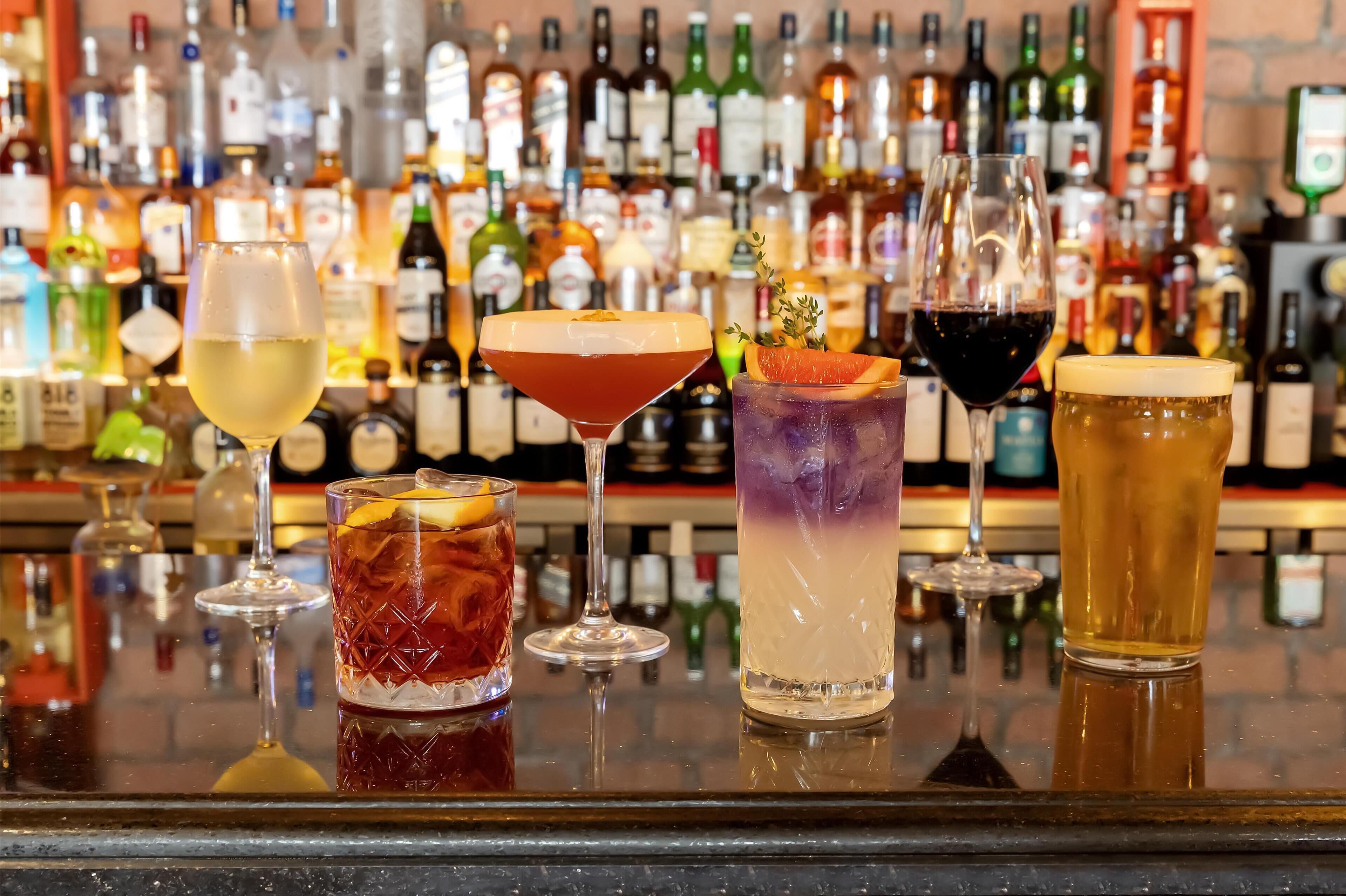 A bar with various drinks and bottles in the background.