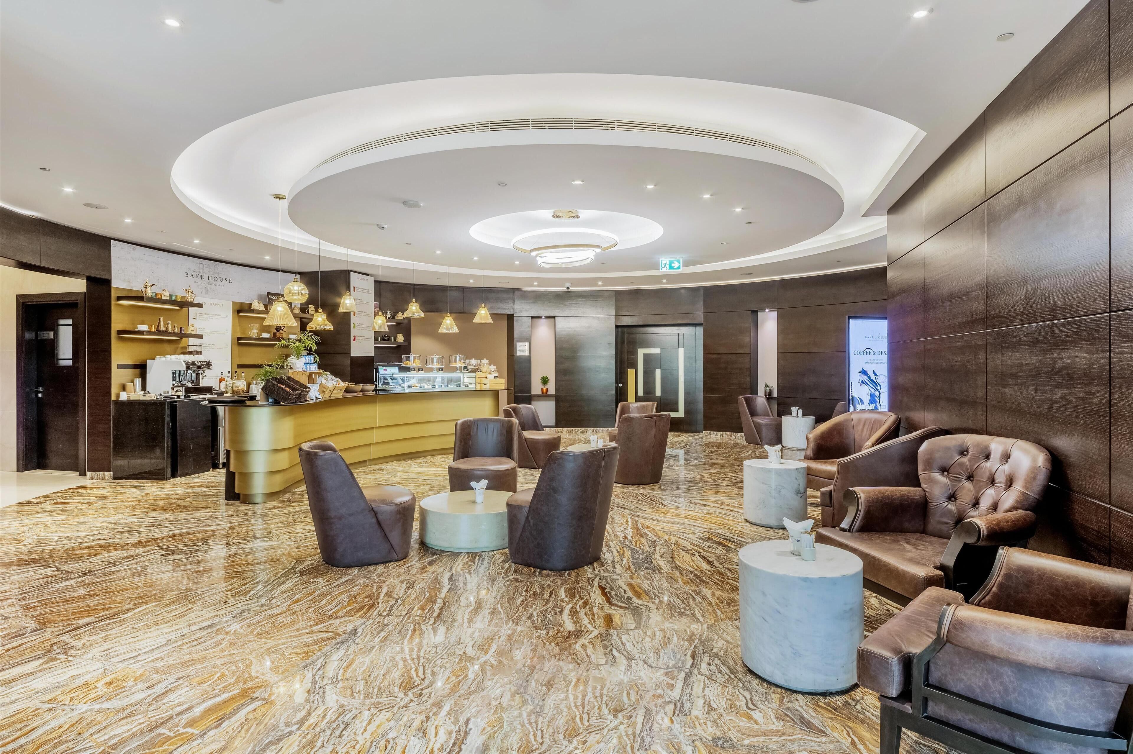 Eine moderne Lobby mit einer zentralen Bar, Sitzgelegenheiten und einem Marmorboden.