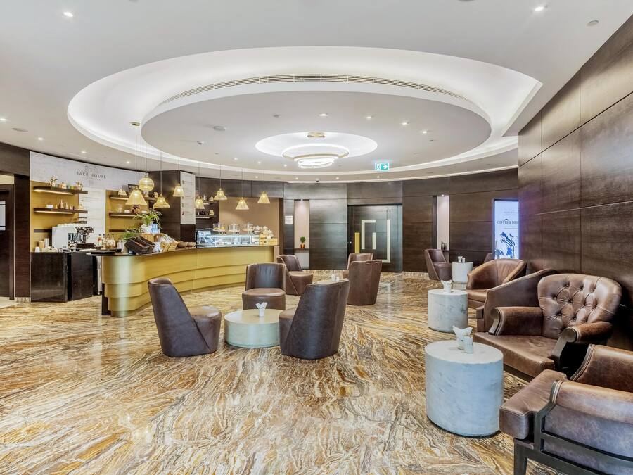 Eine moderne Lobby mit einer zentralen Bar, Sitzgelegenheiten und einem Marmorboden.