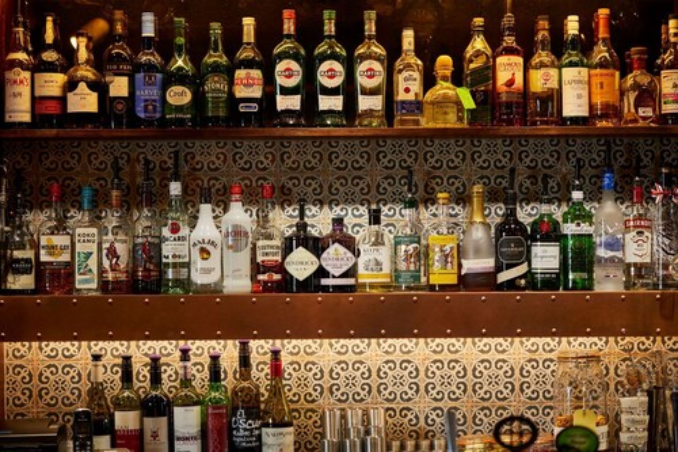Un bar amb diverses prestatgeries plenes de diferents ampolles de licors.
