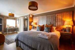 Une chambre à coucher avec un grand lit, des lampes de chevet et une tête de lit en bois.