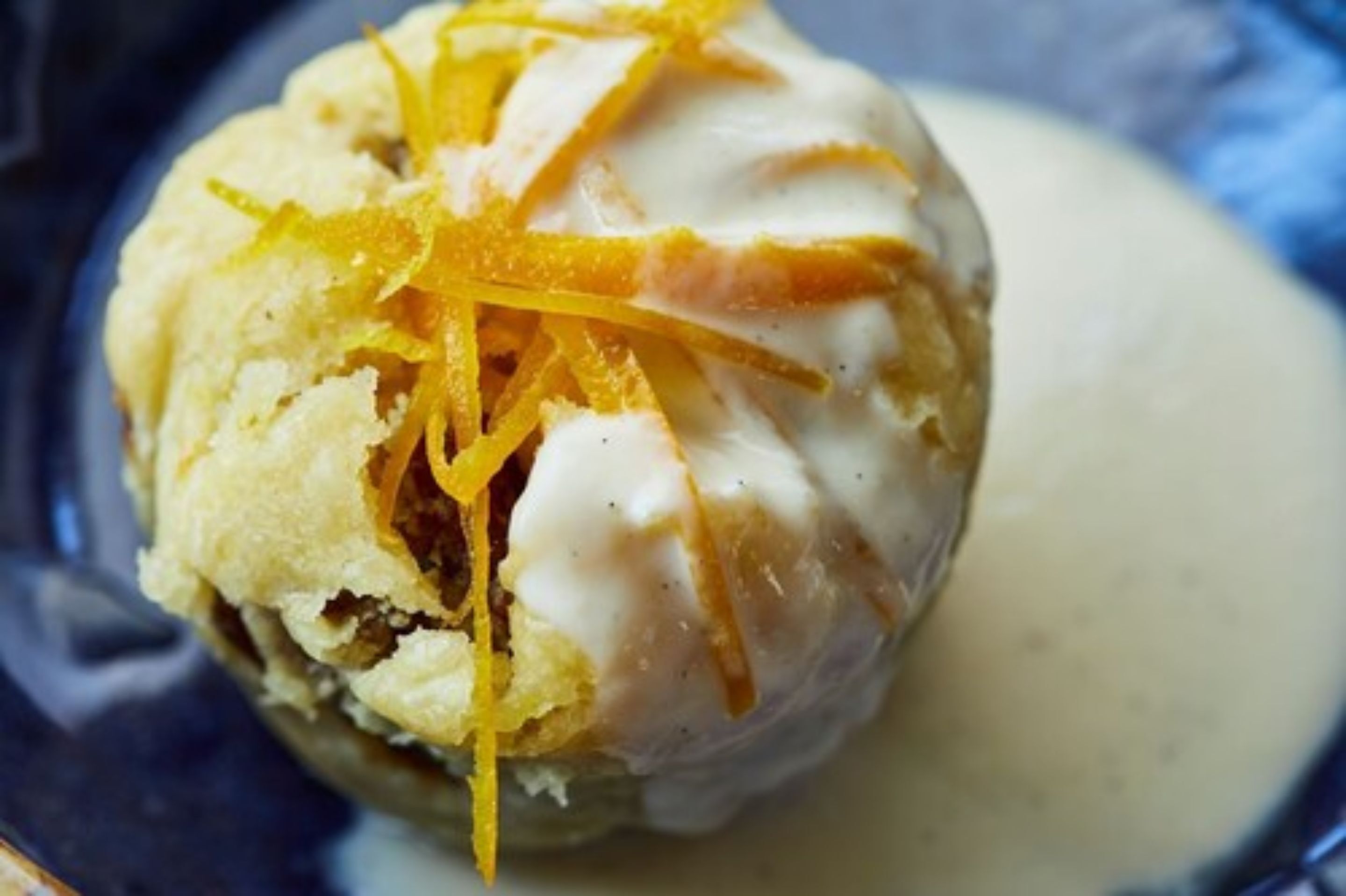 Un dessert con una copertura cremosa e una guarnizione di scorza d'arancia.