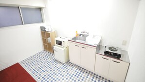 A compact kitchen with a microwave, toaster, sink, and small refrigerator. - GATE80 nagai stadium (Osaka)