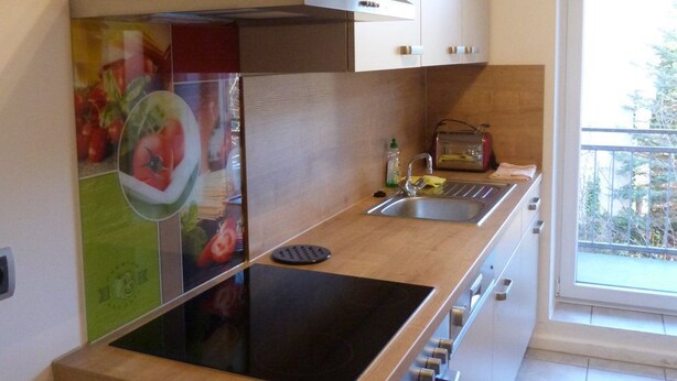 A modern kitchen with a built-in stove, a sink, and a window overlooking a balcony. - Wohnung im Zentrum des Ruhrgebiets (Castrop-Rauxel)
