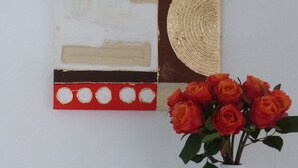 A white vase with red roses on a teal placemat, a wall art piece, and a 'DREAM' sign. - Wohnung im Zentrum des Ruhrgebiets (Castrop-Rauxel)