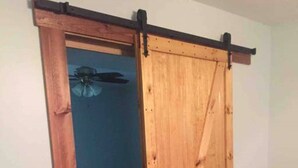 Une pièce dotée d’une porte coulissante en bois qui donne accès à un autre espace.