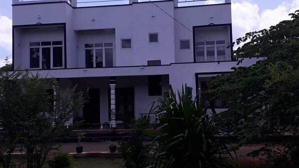 A two-story building with a flat roof, large windows, and a central entrance with a staircase. - Reliance Holiday Resort (Anuradhapura)