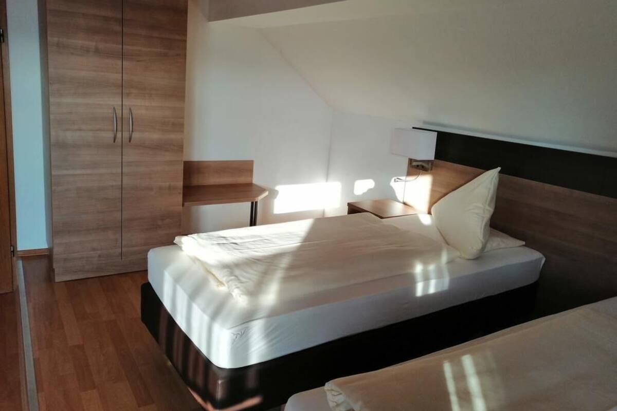 A bedroom with a bed, bedside table, and wardrobe.