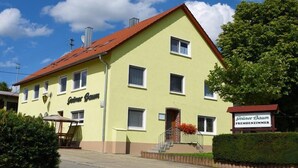 A yellow building with a red roof, named "Günter Baum". - Grüner Baum (Langenau)