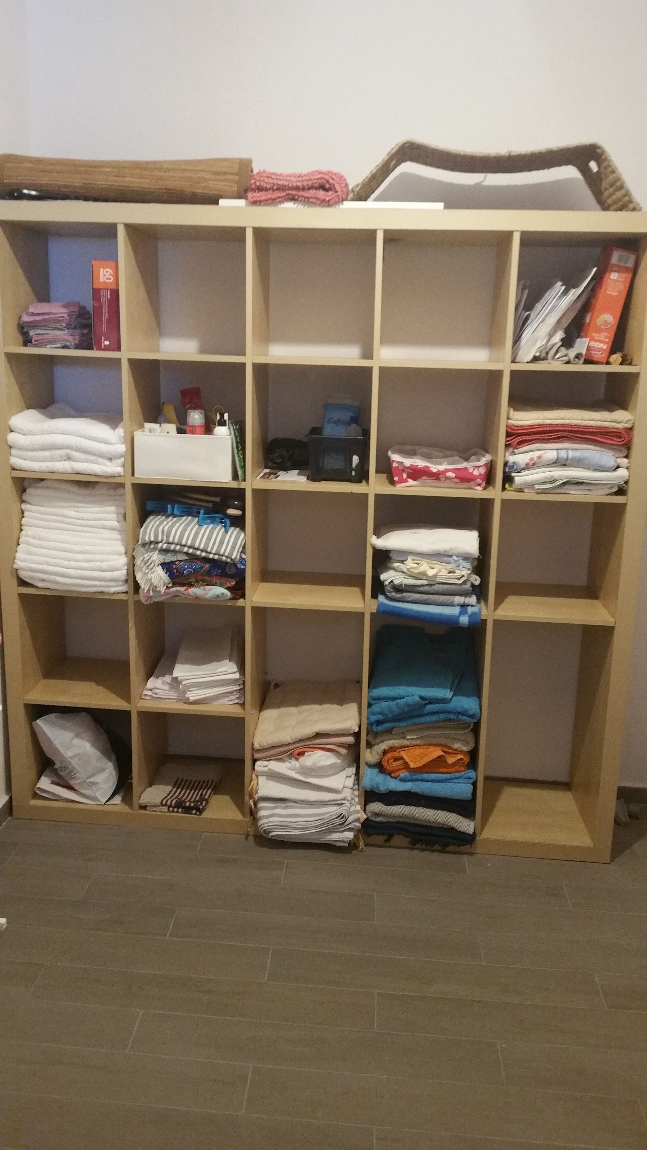 Ein Stauraum mit Regalen, gefüllt mit gefalteten Handtüchern, Decken und anderen Textilien.