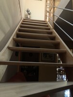 Una escalera de madera con barandales de metal que da a una plataforma.