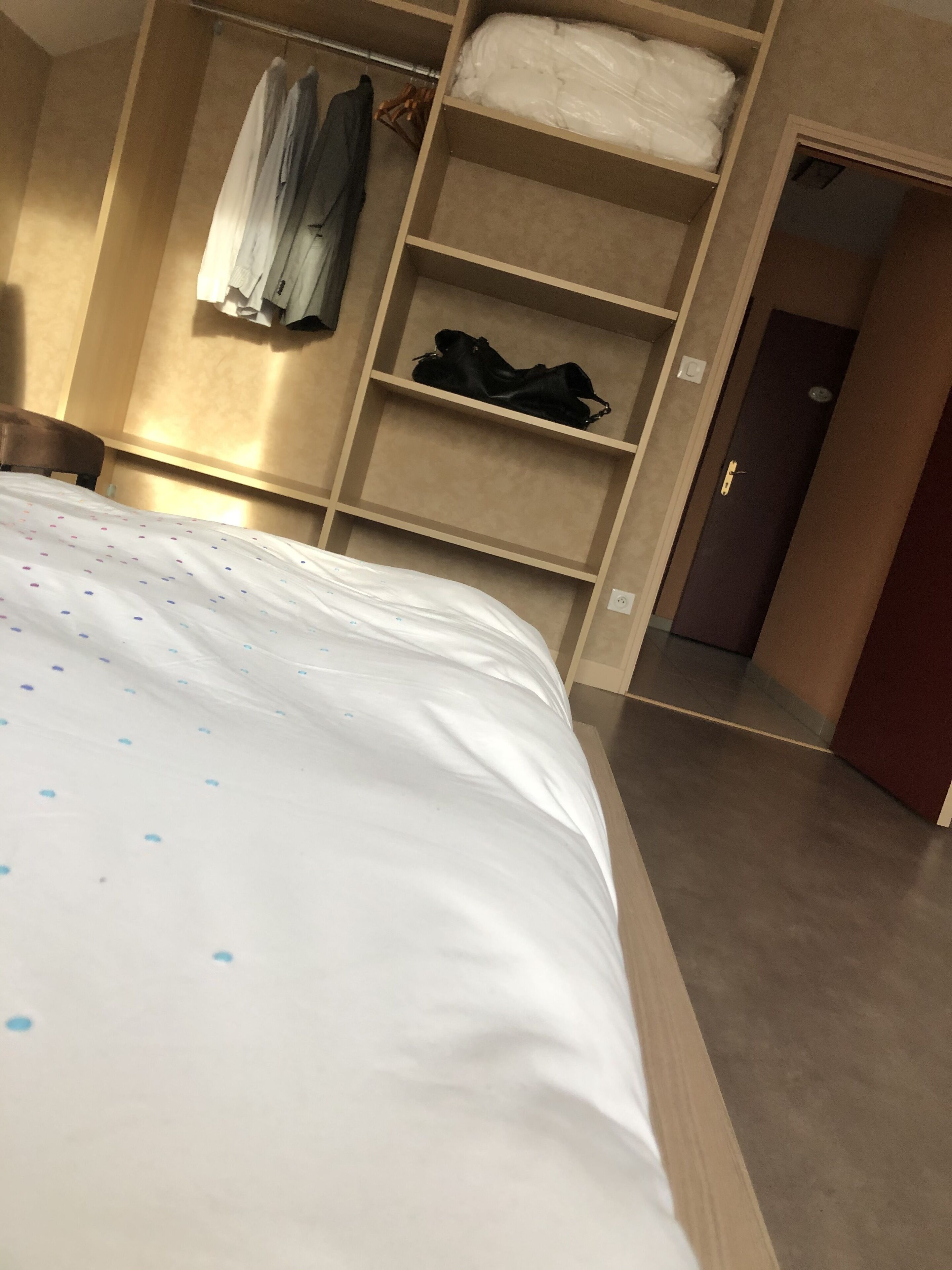 Ein Schlafzimmer mit einem Bett, einem Kleiderschrank und einer Regaleinheit.