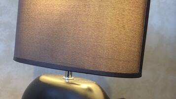 A modern table lamp with a cylindrical base and a fabric shade.