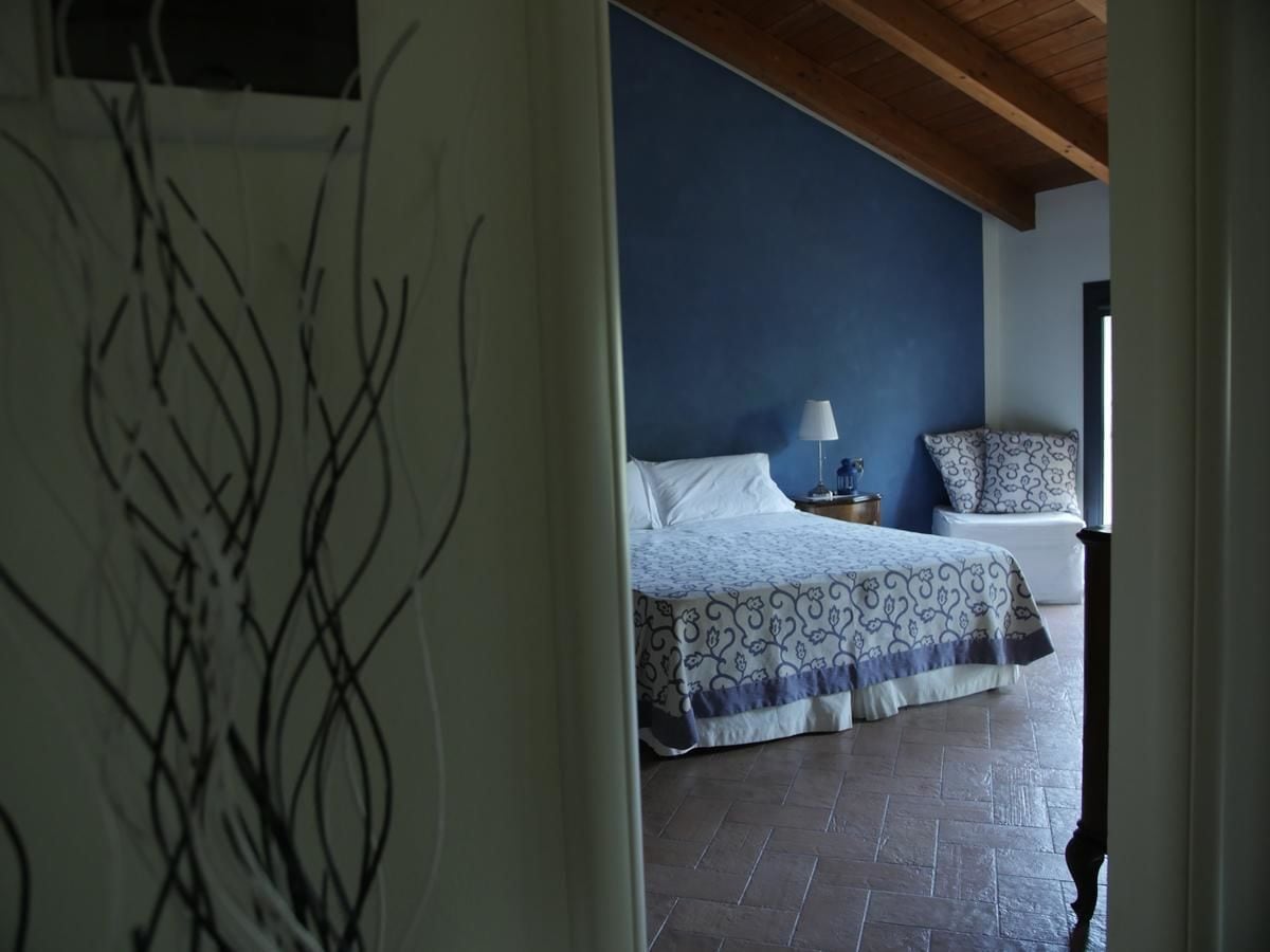 A bedroom with a bed, a nightstand, and a window.