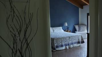A bedroom with a bed, a nightstand, and a window.