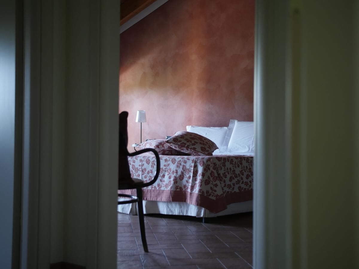 Un dormitori amb un llit, una cadira i una làmpada.