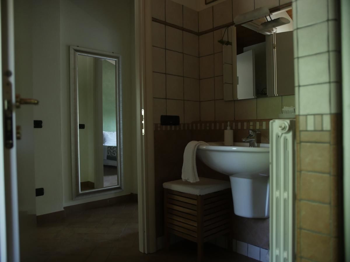 A bathroom with a toilet, sink, and mirror.