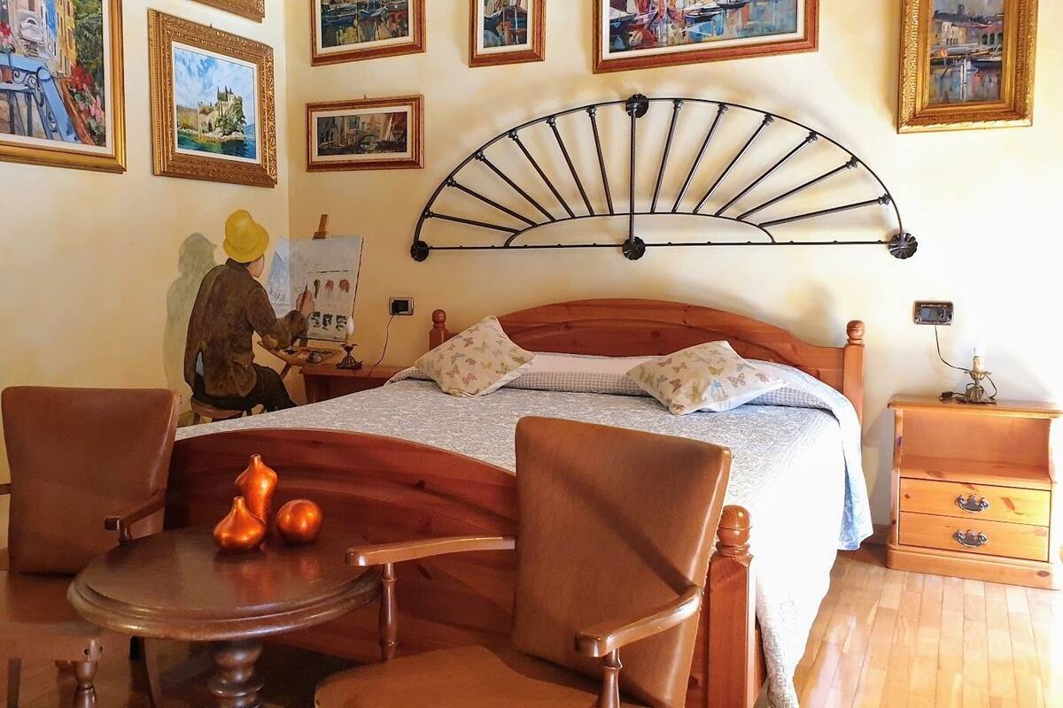 Une chambre à coucher avec un lit en bois, une table ronde avec des chaises et une table de chevet.