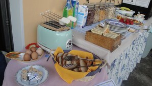 Ein Buffet mit verschiedenen Speisen, darunter Brot, Eier und ein Toaster.
