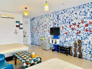 Deluxe Quadruple Room | Living area | Flat-screen TV