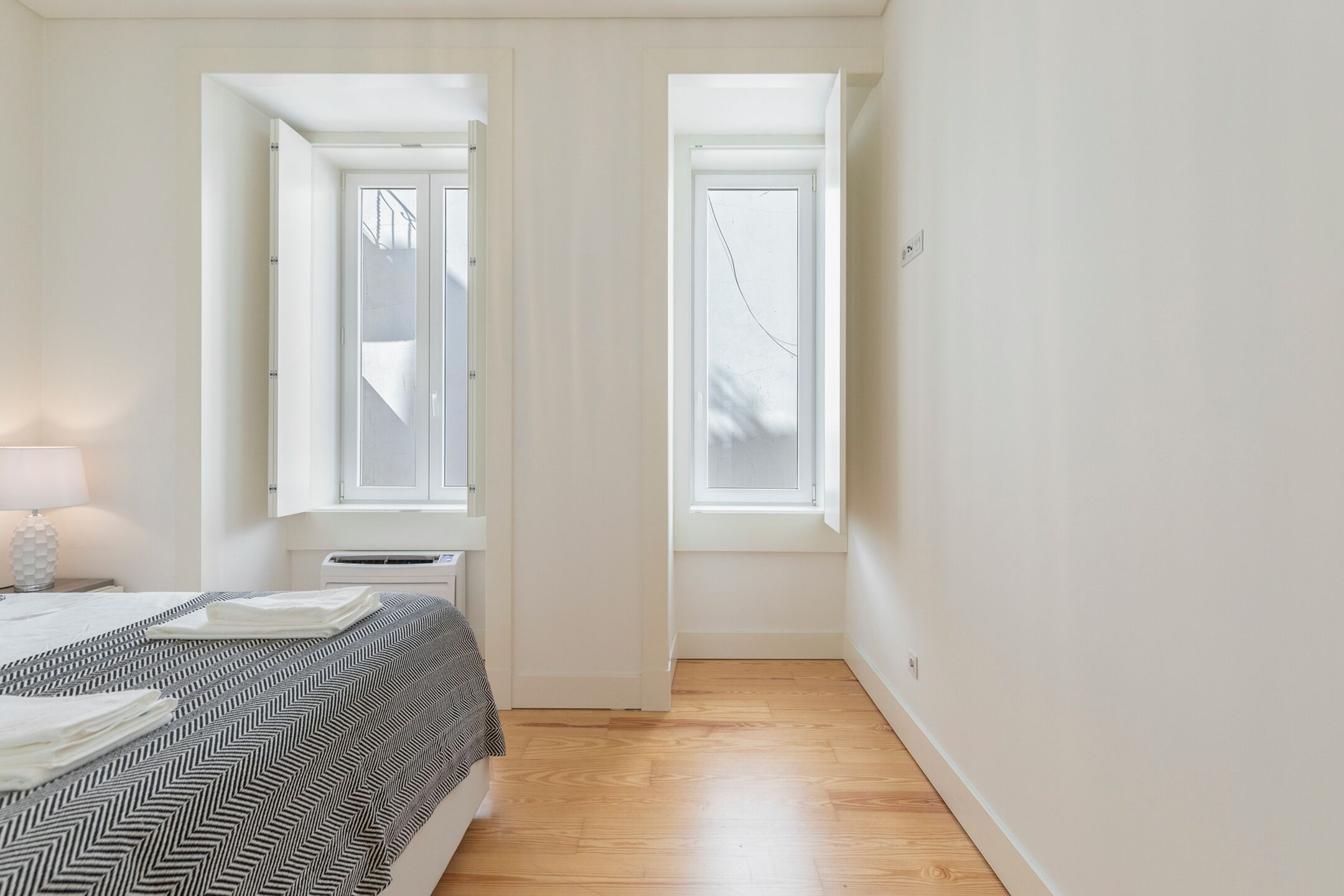 A bedroom with a bed, a window, and a door.
