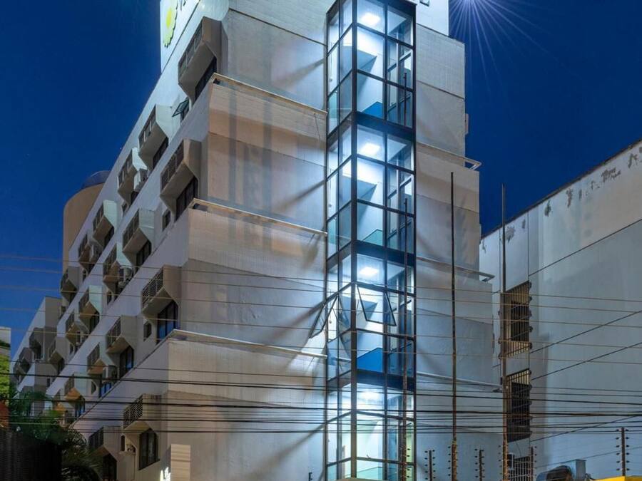 A modern hotel building with a prominent glass facade and a sign reading "Hotel Vila Este."