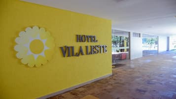 A yellow wall with a sun logo and the text "HOTEL VILA LESTE".