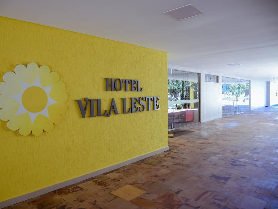 A yellow wall with a sun logo and the text "HOTEL VILA LESTE".