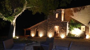 An outdoor seating area with wicker furniture and a stone building in the background. - Pietre di Fiume (San Giorgio del Sannio)