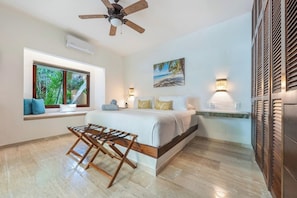 Ein Schlafzimmer mit Bett, Fenster mit Blick, Deckenventilator und Nachttisch.