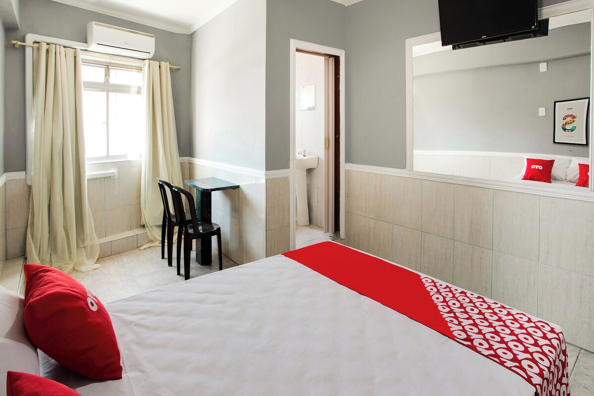 Une chambre d’hôtel comprenant un lit, un bureau, une chaise, une télévision et une salle de bain.