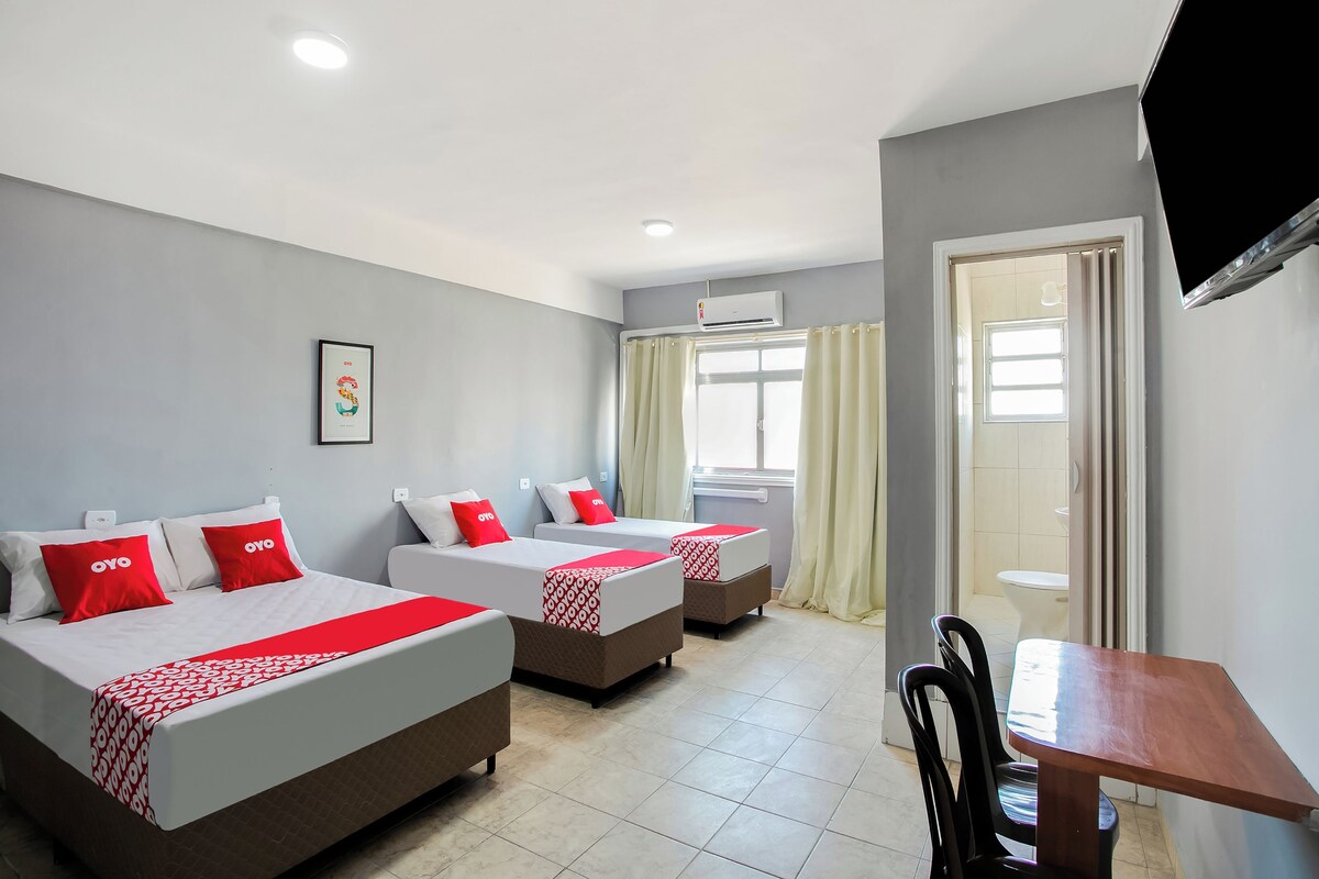 Une chambre d’hôtel avec deux lits, un bureau et une télévision.