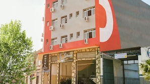 Un hotel con fachada roja y blanca, varios equipos de aire acondicionado y un letrero que indica que es un hotel en Boneville.