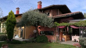 A traditional house with a brick facade, a red-tiled roof, and a small tower. - B&B La Colombera (Lessona)